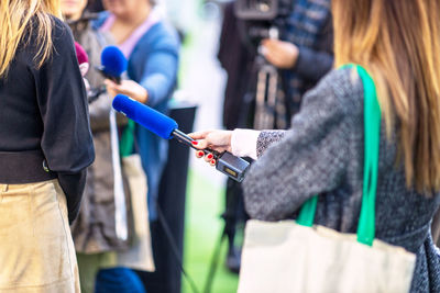 Press, news conference or media scrum, female reporter holding microphone