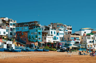 Buildings in city against clear blue sky