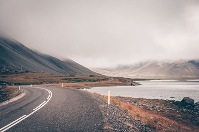 Road by lake against sky