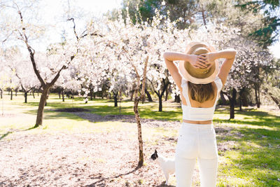 Rear view of woman standing against trees