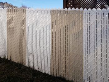 Fence against white wall of building