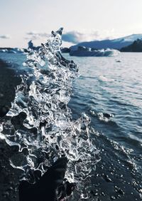 Close-up of person in sea against sky