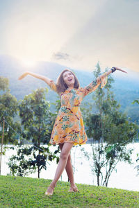 Full length of young woman standing on field