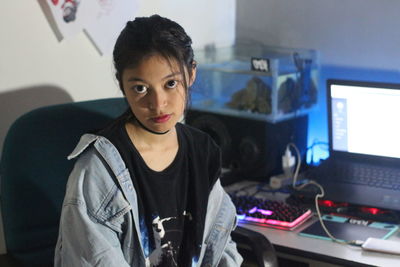 Portrait of girl sitting by computer