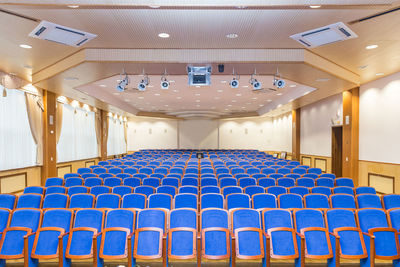 Empty chairs and tables in illuminated room