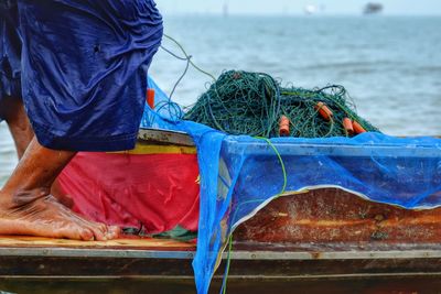 Low section of fisherman with fishing net on boat