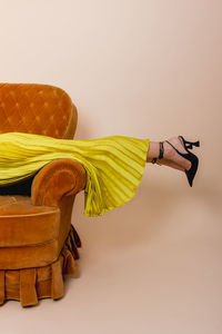 Girl in black shoes resting on the sofa, tired. graceful female model lying on sofa.