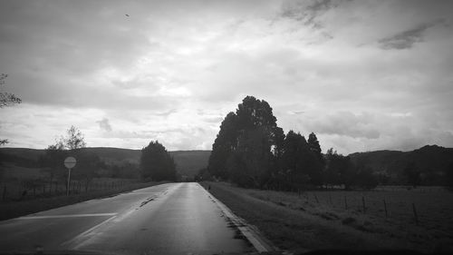 Empty road against cloudy sky