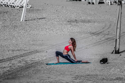 Woman practicing yoga at beach