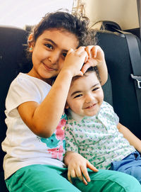 Portrait of happy mother and daughter sitting in car