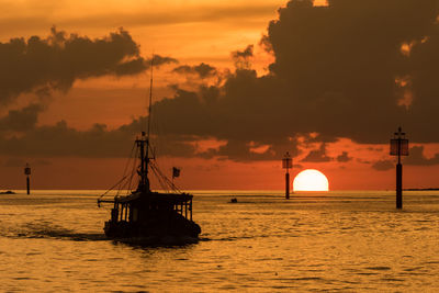 Silhouette sailboat on sea against sky during sunset