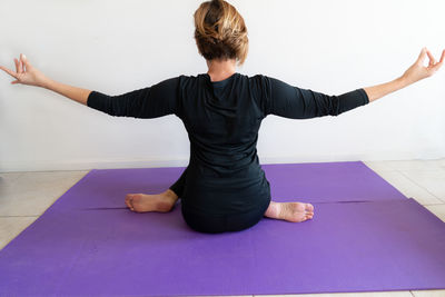 Rear view of woman with arms raised