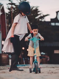 Asian kid play sand at horse ranch while sunset.dramatic low key of simple life style of childhood.