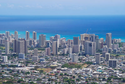 High angle view of buildings by sea against sky