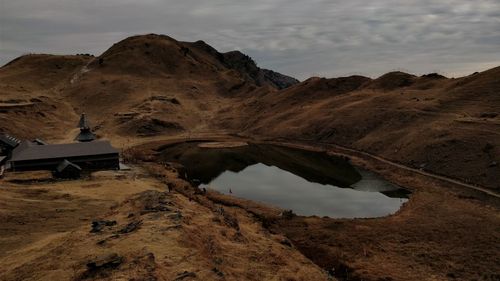 Scenic view of lake by mountains against sky