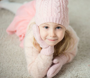 Close-up portrait of cute girl wearing warm clothing at home