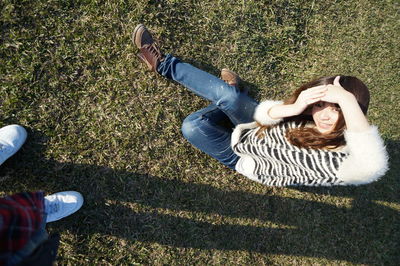 High angle view portrait of young woman sitting on grass