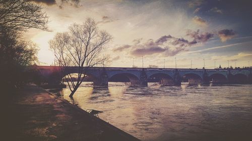 Bridge over river against sky during sunset