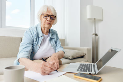 Young woman using laptop at desk in office