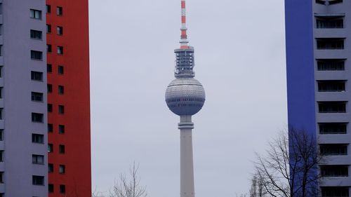 Tv tower in the middle of two houses in the foreground