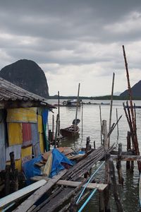 Weathered house and wooden posts against sea