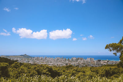 Panoramic shot of city by sea against blue sky