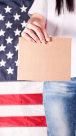 Midsection of woman holding american flag