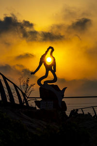 Low angle view of silhouette statue against sky during sunset