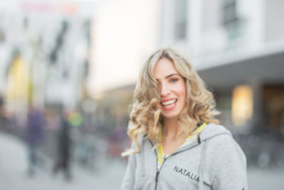 Portrait of smiling young woman in city