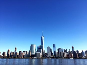 River by one world trade center against clear blue sky