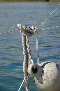 Close-up of rope tied to buoy against sea