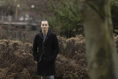 Portrait of young man standing in forest