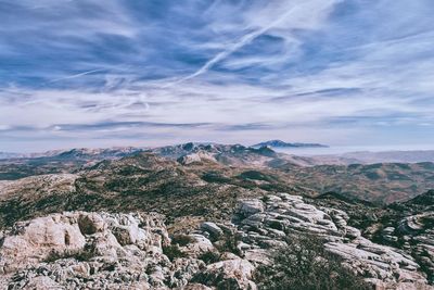 Scenic view of rocky mountains against cloudy sky