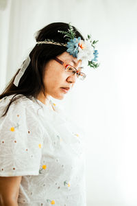 Portrait of woman standing against white background