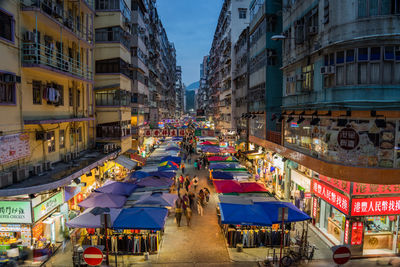 People walking on road along buildings