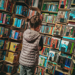 Rear view of person standing in library