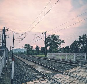 Railroad tracks against sky during sunset