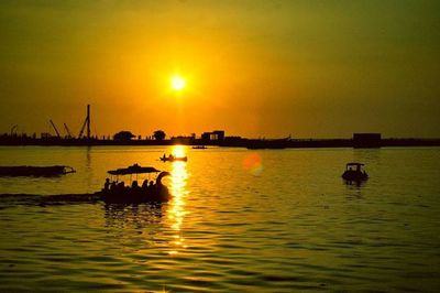 Boat sailing in sea at sunset