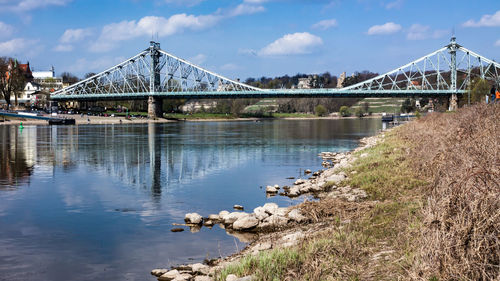 Bridge over river against cloudy sky