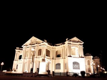 Low angle view of illuminated building against sky at night