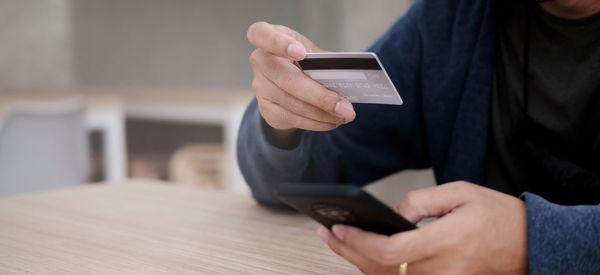 Midsection of man using mobile phone