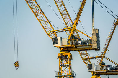 Low angle view of crane against sky