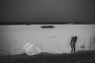 Men in lake against sky