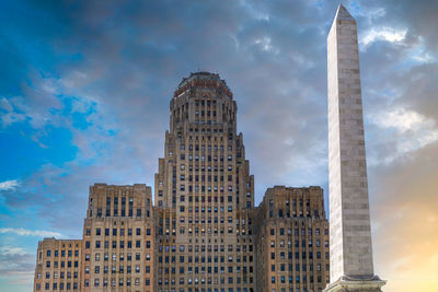 Low angle view of buildings against cloudy sky