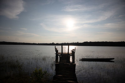 Pier over lake against sky