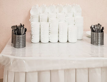 Close-up of potted plants on table against white wall