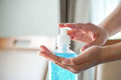 Midsection of woman holding glass bottle