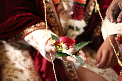 Midsection of woman holding flowers on floor