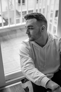 Young man sitting by window at home