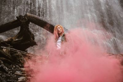 Full length of young woman splashing water